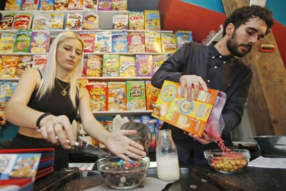 Staff Abigail Hickey and Joshua Puleston serve cereal at the "Cereal Killer Cafe" in east London